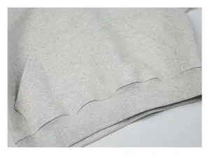 Close-up detail of a grey heavy cotton hoodie showing kangaroo pocket and ribbed hem texture.