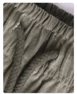 Detailed macro shot of vintage washed faded olive green cotton fabric texture