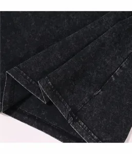 Gros plan détaillé du tissu en coton noir délavé à l'acide et de la couture de l'ourlet.