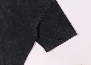 Détail d'un t-shirt noir délavé à l'acide avec manches tombantes et texture vintage authentique