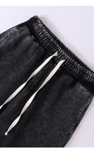 Détail du pantalon de sport noir délavé à l'acide avec taille élastique et cordon blanc