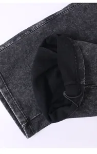 Gros plan du tissu denim délavé neige et cordon de serrage sur pantalon large décontracté