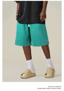 Vue détaillée d'un short lourd vert lavé porté avec des chaussettes et des claquettes
