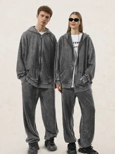 Deux mannequins portant un ensemble streetwear sweat à capuche et jogging gris délavé.