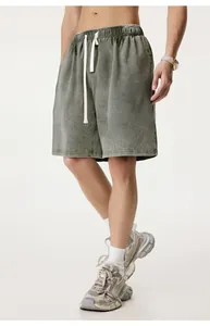 Men's olive green washed distressed shorts detail with white drawstring waist.