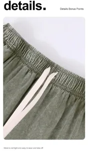 Macro detail of the elastic drawstring waistband on vintage washed olive cotton shorts