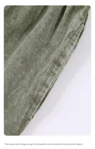Detail shot of a side pocket on olive green washed cotton shorts with distressed texture