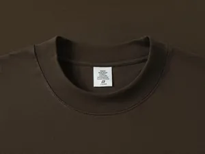 Vista detallada del cuello redondo y la etiqueta de una camiseta de algodón marrón pesado