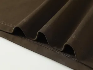 Primer plano detallado del dobladillo de una camiseta de algodón marrón pesado con doble costura