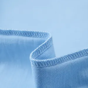 Close-up of precise double-needle four-thread stitching on a light blue cotton T-shirt