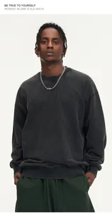 Model wearing dark gray distressed washed oversized sweatshirt in a relaxed street style