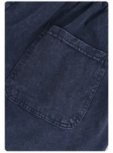Detail of a large pocket on vintage washed navy cotton shorts, part of an oversized set.
