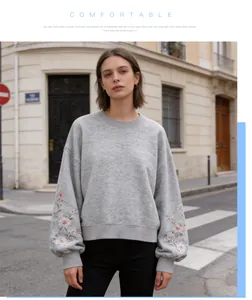 Detailed view of grey crewneck sweatshirt with floral embroidered sleeves