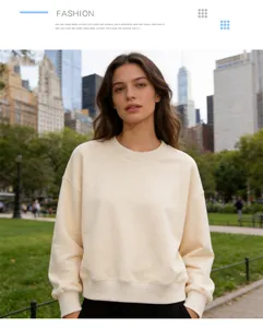 Detail shot of a cream-colored crew neck sweatshirt worn in an outdoor urban setting