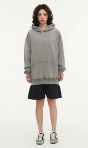 Detailed front view of a vintage washed grey oversized hoodie worn by a model in studio