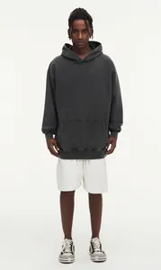 High-quality detail of a vintage washed charcoal gray oversized hoodie worn by a male model