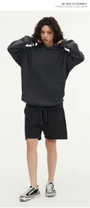 Full body view of a woman wearing a vintage washed charcoal grey oversized hoodie