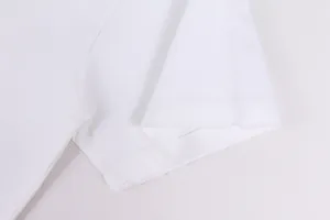 Detailed macro shot of the distressed raw hem on a white heavyweight cotton T-shirt sleeve