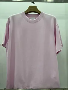 Vue détaillée d'un t-shirt rose en coton épais de qualité sur un cintre en bois