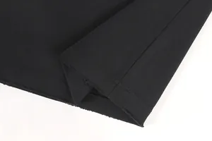 Detailed macro shot showing distressed raw edge hem on heavy 420g black cotton T-shirt
