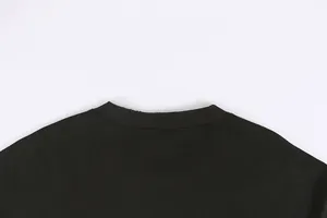Macro close-up showing the distressed edge detail of the black heavy cotton crew neckline