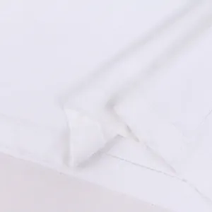Macro detail of the distressed hem on a premium heavyweight white cotton t-shirt