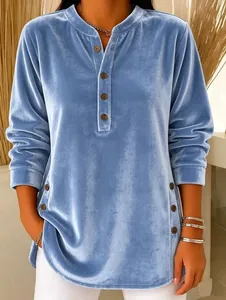 Close-up detail of a soft blue velvet long-sleeved top with decorative side buttons.