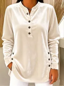 Detailed view of women's golden velvet long-sleeve top featuring decorative buttons