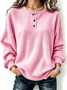 Gedetailleerde close-up van de roze wafelstructuur op een ruimvallend Henley sweatshirt
