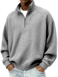 Détail de la texture gaufrée grise du sweat-shirt pour hommes à col montant zippé.