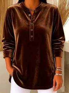 Detailed close-up view of brown gold velvet long-sleeved top with stylish buttons and texture