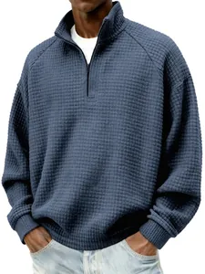 Gros plan du sweat à col zippé en maille gaufrée bleue montrant les détails du tissu.