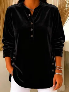 Close-up of elegant black velvet V-neck long sleeve top with button details