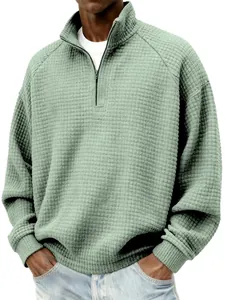 Détail d'un sweat-shirt vert sauge avec fermeture éclair et texture gaufrée