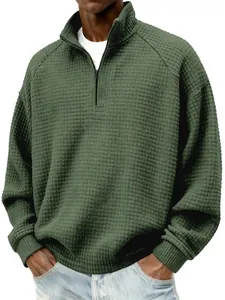 Gros plan d'un sweat-shirt vert foncé à texture gaufrée avec col montant à glissière