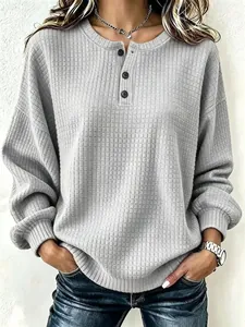Detailweergave van grijze wafelgebreide sweatshirt met knoopsluiting bij de hals