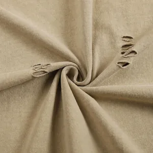 Macro view of 260g heavyweight washed cotton fabric featuring distressed ripped details.