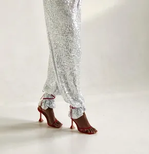 Detail view of silver sequined straight-leg trousers with shimmering texture and stylish fit