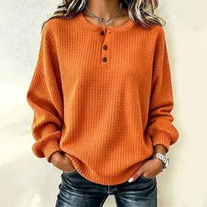 Oranje wafelgebreide damessweatshirt met ronde hals en stijlvolle knoopdetails