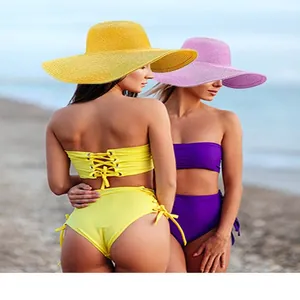 Detail of high-waisted bikinis and wide-brim sun hats on a sunny beach