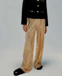 Detailed view of high-waisted golden sequin wide-leg trousers with shimmering metallic finish