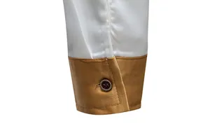 Nahaufnahme der Manschette eines Herren-Satinhemdes mit goldenem Farbblockdesign