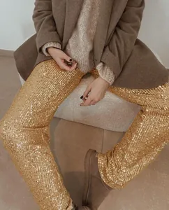 Detail shot of sparkling gold sequined straight-leg pants for festive and party outfits
