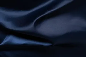 Detailaufnahme von marineblauem Satinstoff mit seidiger Textur und elegantem Glanz für Hemden