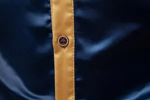 Nahaufnahme des hochwertigen navyblauen Satinstoffs und des Knopfes an einem Hemd