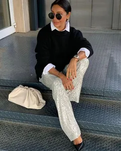 Detailed street style view of high-fashion women's silver sequin straight casual pants