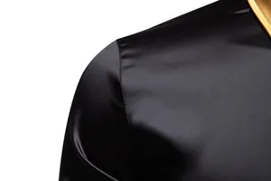 Nahaufnahme von schwarzem Satin-Stoff und goldenem Kragen an einem Herrenhemd.