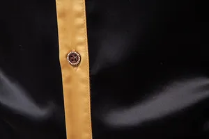 Detaillierte Nahaufnahme der goldenen Satinknopfleiste an einem schwarzen Herrenhemd