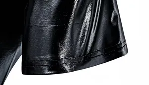 Close-up of black shiny metallic fabric showing fine texture and hem stitching