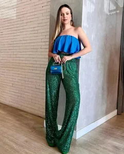 Full body view of the emerald green sequined trousers showing fit and shimmering effect